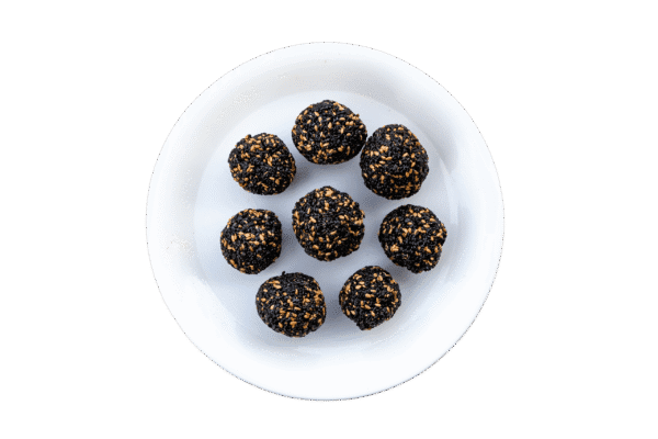 A plate of sesame til ladoo in white background . Buy Til ladoo online, ; sesame ladoo