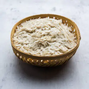 Raw Flattened Rice or Thick or thin Rice Flakes for Namkeen Chivda snacks or Aloo Poha for Indian Breakfast, served in a bowl