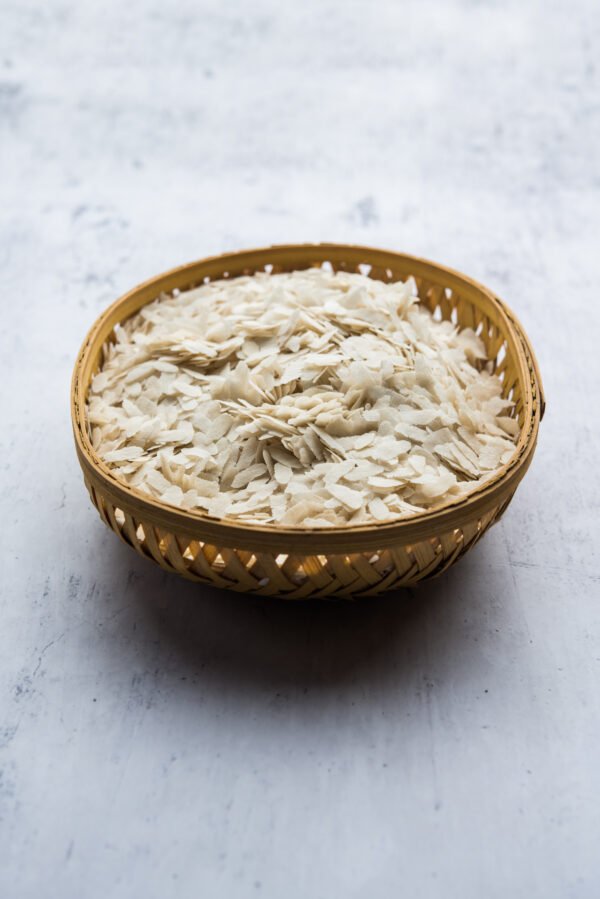 Raw Flattened Rice or Thick or thin Rice Flakes for Namkeen Chivda snacks or Aloo Poha for Indian Breakfast, served in a bowl