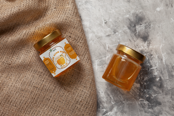 Assamese Raw Honey by assamyumm in a glass jar in a light background